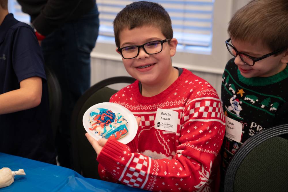 A kid showing off the cookie he decorated.
